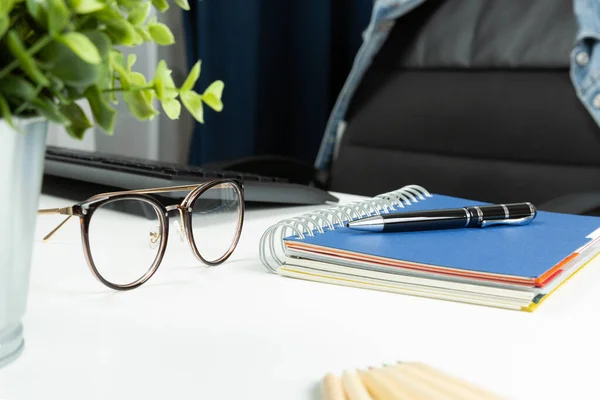 Hemmakontor och tom stol. Anteckningsbok, penna och glas på d — Stockfoto