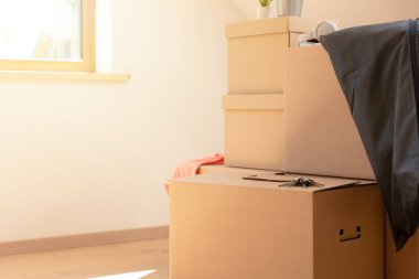 Çekil şuradan. Yeni, temiz bir eve taşınmak için karton kutular. Güneşli bir günde, tavan arasındaki bir pencerenin yanında..