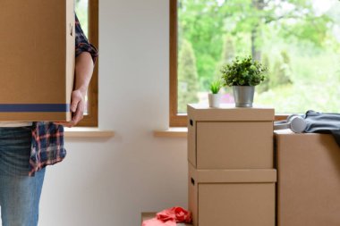 Move. Cardboard boxes for moving into a new, clean home. In a sunny day by a window in attic. clipart