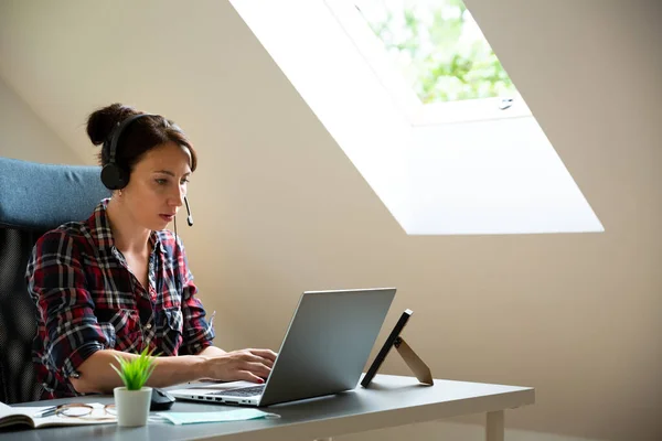 Bautifull women on a conforence call in home office. Working from home.