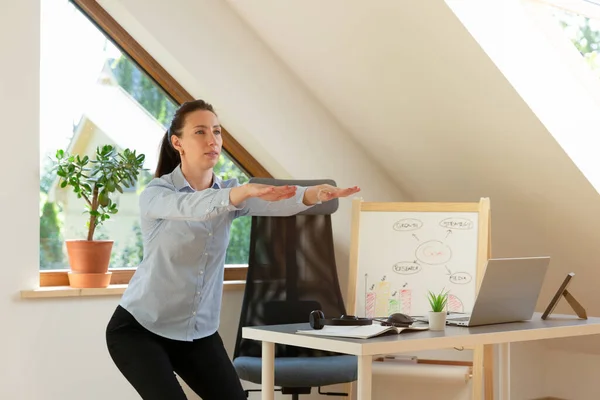 漂亮的女人在笔记本电脑前做运动和伸展身体 在家工作 健康概念 — 图库照片