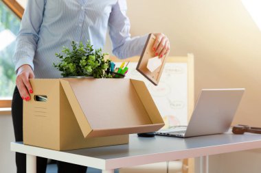 Güzel bir iş kadını bir kutu ofis eşyası taşıyor. Yeni iş tanıtımı ya da işten ayrılma.