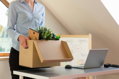 Güzel bir iş kadını bir kutu ofis eşyası taşıyor. Yeni iş tanıtımı ya da işten ayrılma.