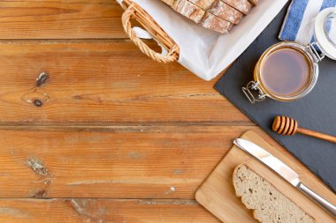 Eski ahşap bir masada organik bal ve kırsal ekmek. Sağlıklı kahvaltı..