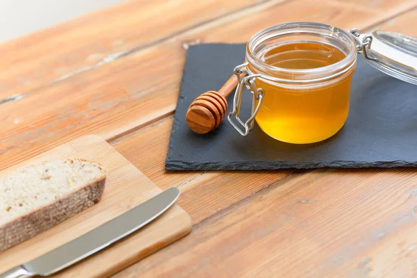 有机蜂蜜和乡村面包放在一张旧木桌上 健康的早餐 — 图库照片