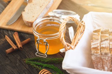 Eski ahşap bir masada organik bal ve kırsal ekmek. Sağlıklı kahvaltı..
