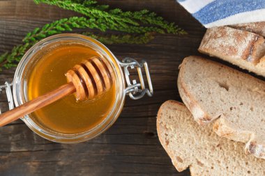 Eski ahşap bir masada organik bal ve kırsal ekmek. Sağlıklı kahvaltı..