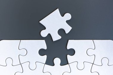 Gri arkaplanda beyaz yapboz parçaları