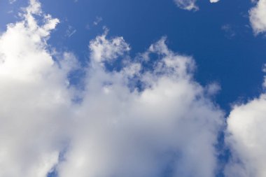 Beyaz bulutlar ve parlak güneş mavi gökyüzü.