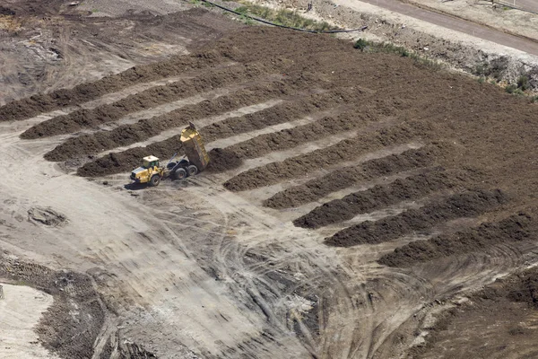 Soil trucks delivering soil for filling land.