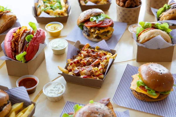 Takeaway burger restaurant layout with loaded fries placed with sauces and menu item selection.