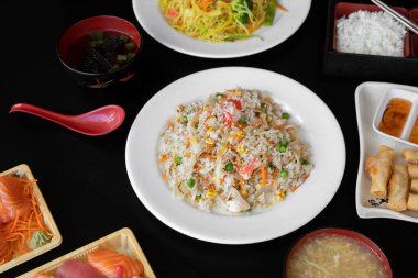 Siyah bir masa yüzeyine yerleştirilmiş Çin yemeği menüsü ögeleri.