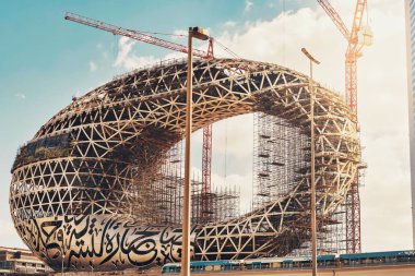 DUBAI, UAE - JAN 20, 2019: The construction of the Museum of the Future one of the world's most advanced buildings. Metro passing by. Opening 2019 clipart