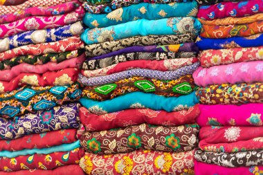 Canlı renklerde tekstil yığılmış, tüm kumaş üzerinde süsler