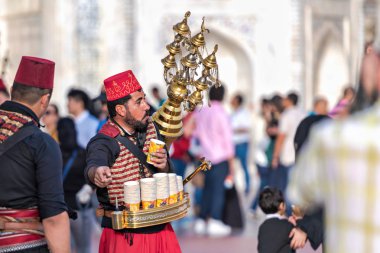 Sırtında pirinç konteyner ile kırmızı bir fes Coffe satıcı
