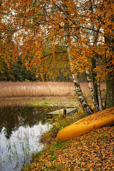 Närbild av en gul kanot strandsatt vid viken under en gul trasa — Stockfoto