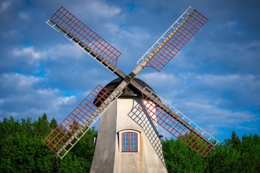 Ormanı ve mavi bulutlu yaz gökyüzü olan Windmil. İsveç