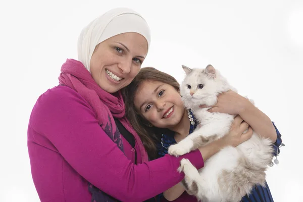 Glückliche muslimische Mutter & Mädchen und eine weiße Katze — Stockfoto