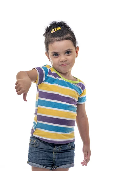Ganska litet kvinnligt barn med tummen ner uttryck, ogillar — Stockfoto