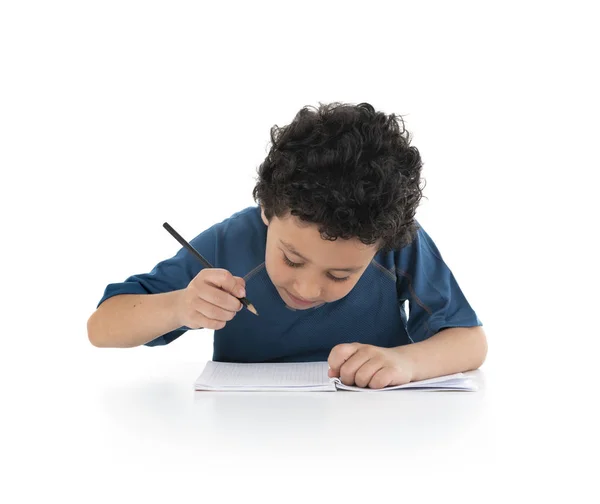 Retrato de un niño joven estudiando y haciendo trabajos a domicilio, escribiendo con —  Fotos de Stock