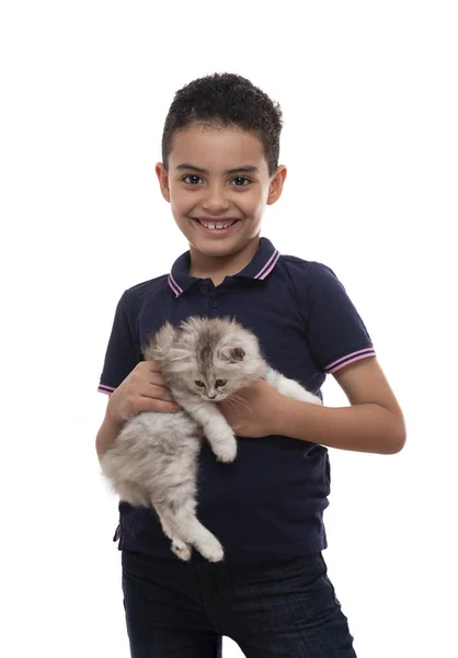 Een gelukkige jonge jongen glimlachend met harige kitten, het houden van zijn huisdier, is — Stockfoto