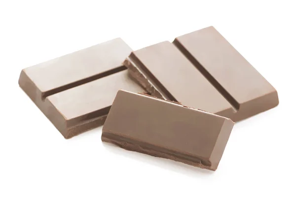 Pièces de chocolat brun foncé fissurées sur fond blanc — Photo