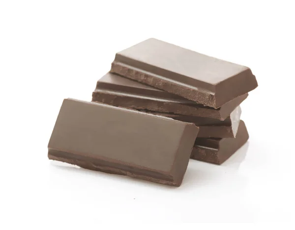 Montón de piezas de chocolate marrón oscuro sobre fondo blanco — Foto de Stock