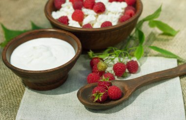 çilek süzme peynir ekşi krema bir dokuma kumaş üzerine bir çömlek içinde ahududu şube