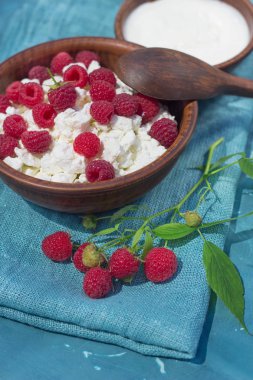 çilek süzme peynir ekşi krema toprak üzerinde kumaş mavi arka plan yakın çekim ile ahududu şube