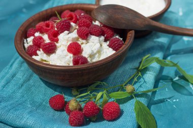 çilek süzme peynir ekşi krema toprak üzerinde kumaş mavi arka plan yakın çekim ile ahududu şube