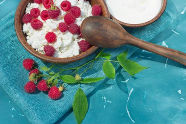 çilek süzme peynir ekşi krema toprak üzerinde kumaş mavi arka plan yakın çekim ile ahududu şube