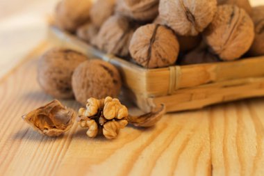 Bütün ceviz ve ekolojik ambalaj ahşap sepet ahşap bir masa üzerinde yapılmış soyulmuş ceviz kabuğu kapat