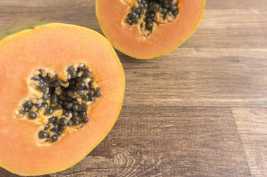 Papaya ikiye kesilmiş ahşap arka plan üzerinde Kapat.