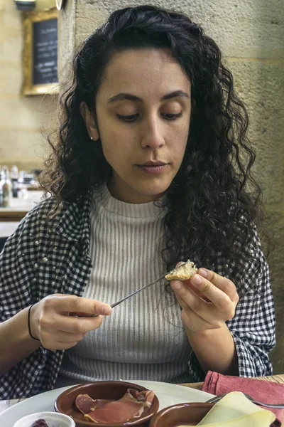 Woman in restaurant eating appetizers