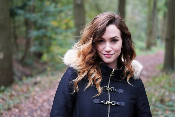 Jovem mulher vestindo casaco de inverno na floresta — Fotografia de Stock