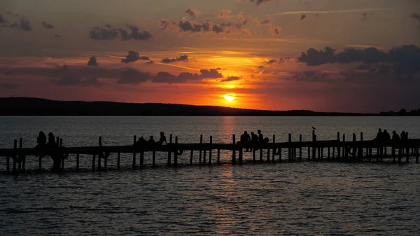 Grupp oigenkännlig människor i siluett titta på solnedgången sundown — Stockfoto