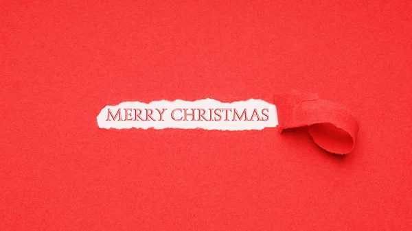 Merry christmas greeting gezien door gat in rood papier achtergrond — Stockfoto