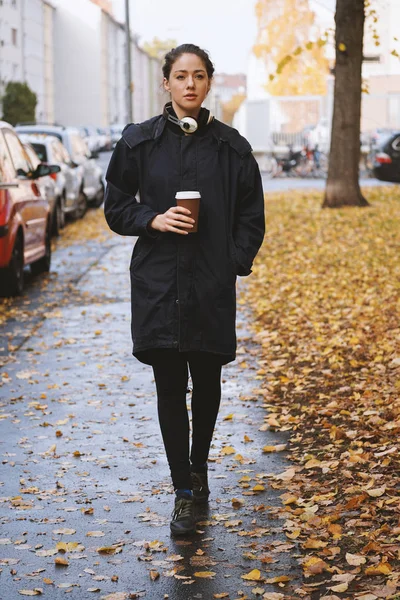 Jeune femme marchant le long de la rue de la ville en automne — Photo
