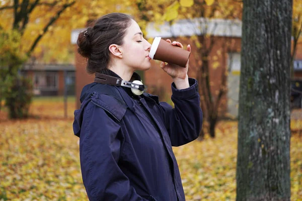 秋天散步时喝咖啡去的年轻女子 — 图库照片