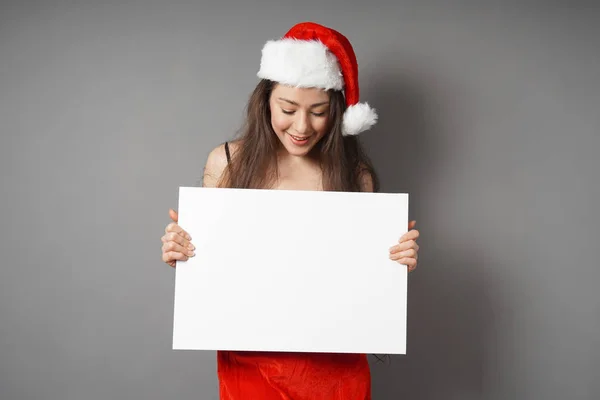 Vrouwelijke santa kijken neer op leeg bord met kopie ruimte — Stockfoto