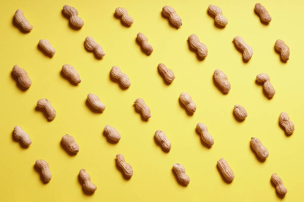 rows of peanuts arranged on yellow background