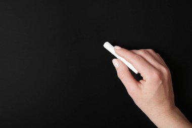 Tebeşir ile boş kara tahta arka plan üzerinde yazma el