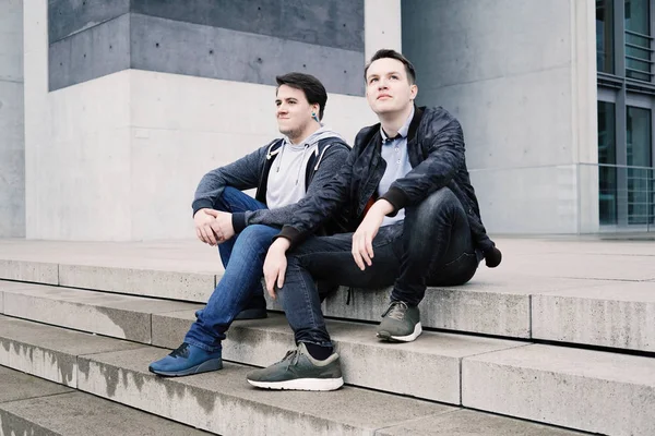 Dos amigos adolescentes masculinos sentados en escalones concretos afuera — Foto de Stock