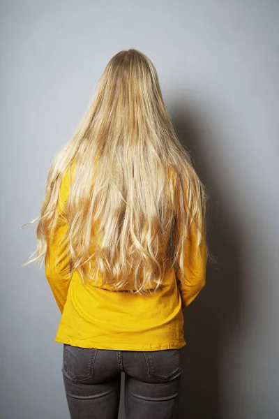 Bakifrån av ung kvinna med långa blonda hår — Stockfoto