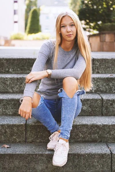 teenage girl sitting on steps outside