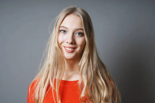 Glückliche junge Frau mit langen blonden Haaren und strahlendem Lächeln — Stockfoto