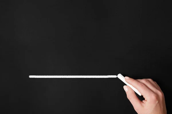 Hand drawing chalk line on chalkboard — Stock Photo, Image