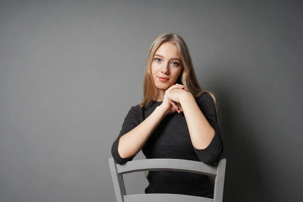 Serene ung kvinna sitter grensle på stol — Stockfoto