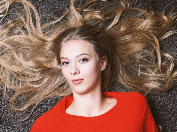 Young woman with her long blond hair spread out — Stock Photo, Image