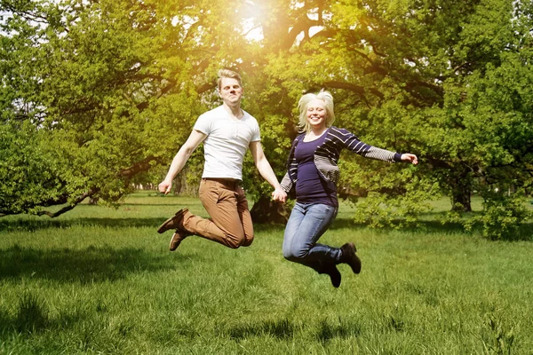 Молода пара стрибає з радістю в природі — стокове фото
